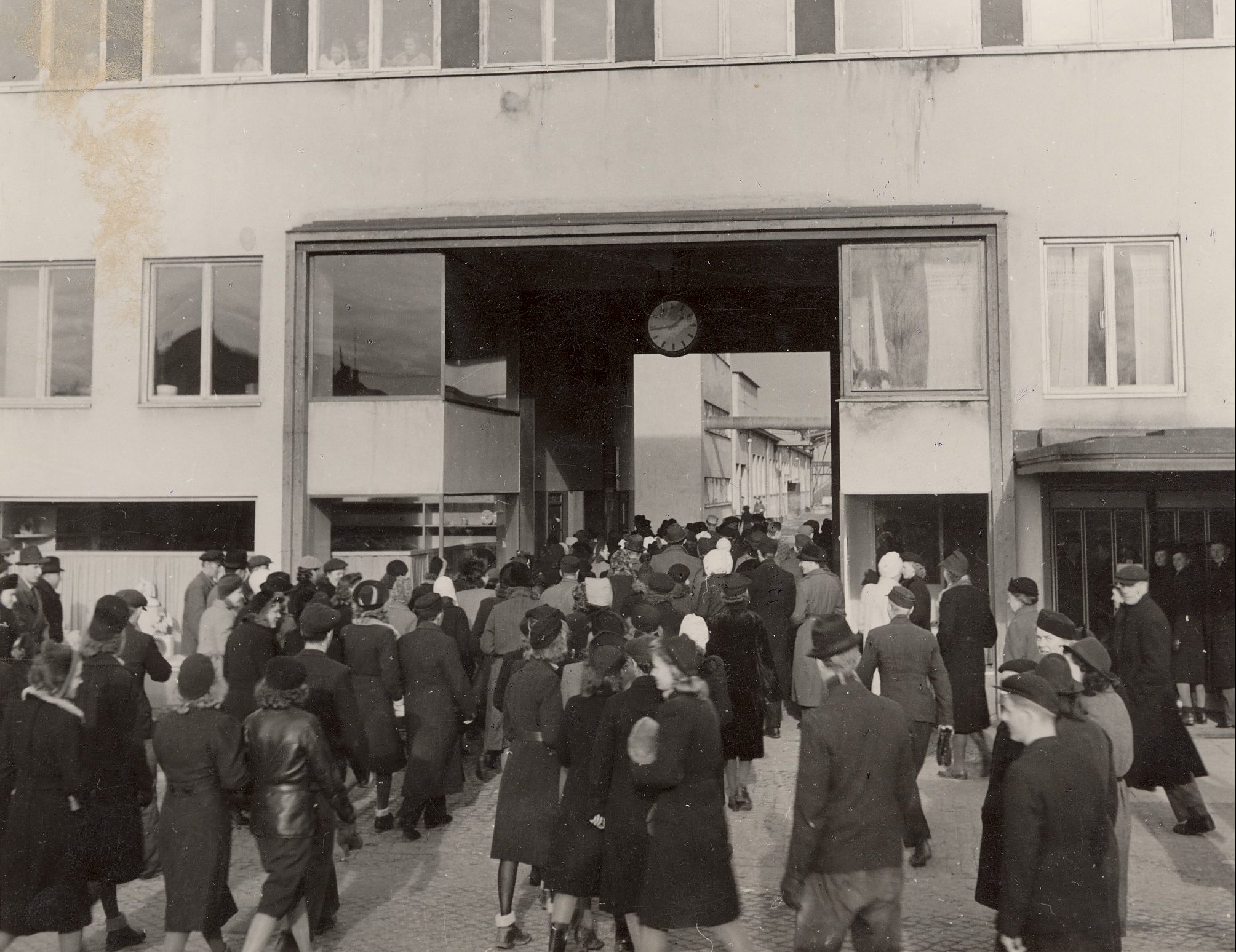 Svartvit arkivbild på arbetare som strömmar in genom porten till Rörstrands fabrik i Lidköping.